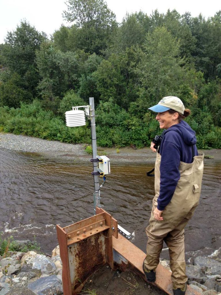 Sue Mauger beside beadedstream D505 datalogger while monitoring the stream temperature monitoring system in Cook Inlet watershed